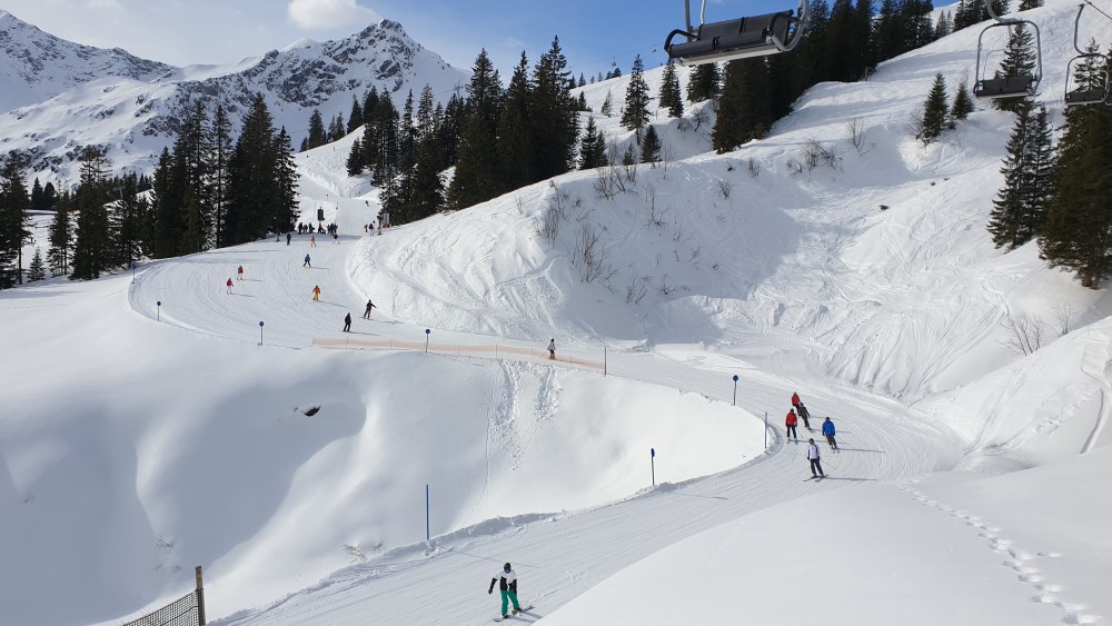 Wintersporters in het Kleinwalsertal op een bospad.